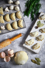 Homemade raw dumplings with potatoes. Cooking dumplings with mashed potatoes on a wooden board. Top view