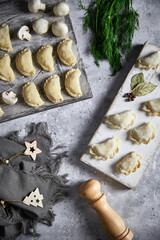 Homemade raw dumplings with potatoes. Cooking dumplings with mashed potatoes on a wooden board. Top view