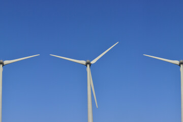 Fototapeta premium À la croisée des éoliennes en plein ciel bleu, France