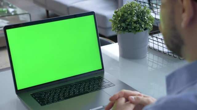 Hands of man at chroma key green screen laptop computer gesturing during an online video conferene with employees or customer - distant work, technology concept 4k template
