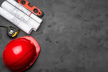 Construction worker hardhat, blueprints and .construction level, top view