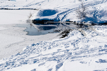 Fototapeta premium Spacious snow landscape. River and hills in Russia, white winter on the terrain, a lot of fluffy snow and ice