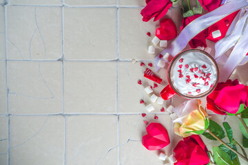 Valentine hot chocolate or coffee, Two red cups with hot chocolate or latte drink, with whipped cream ans sugar heart sprinkles, with roses bouquet ad gift box