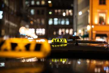 Yellow TAXI signs on the taxis captured at night