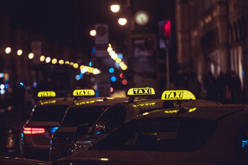 Yellow TAXI signs on the taxis captured at night