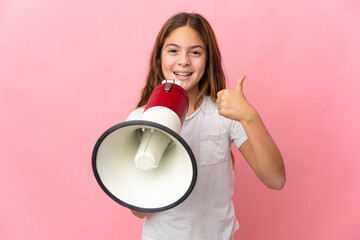 Child over isolated pink background shouting through a megaphone to announce something and with thumb up