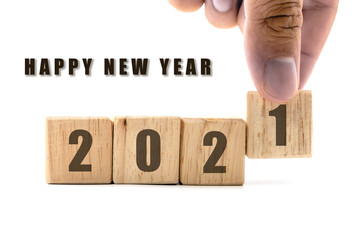 2020 square wooden block with hand picked number 1 placed behind number 2 and new year greeting message on white background