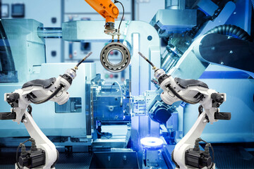 Industrial welding robot and gripping robot working with metal parts on smart factory, on machine blue tone color background, industry 4.0 and AI, automation robotic work instead on human concept