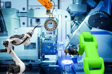 Industrial welding robot and gripping robot working with metal parts on smart factory, on machine blue tone color background, industry 4.0 and AI, automation robotic work instead on human concept