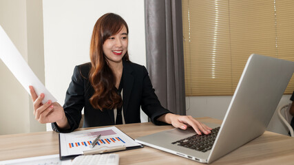 Business women work with laptops and graph paper in the office