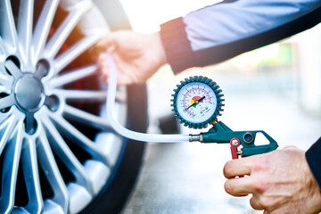 Detail of inflating tire and checking air pressure with gauge pressure