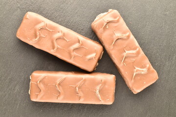 Three chocolate energy bars, close-up, on a serving slate board.