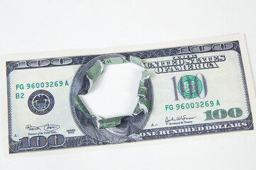 a hundred-dollar bill is torn in the center on a white background