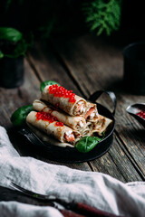 pancakes with red caviar fish and cream cheese on a wooden background
