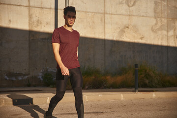 Man walking past a tall concrete wall