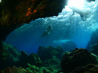 Fototapeta na wymiar woman lady free diving apnea underwater cave sun beams and rays ocean scenery with human