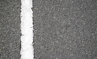 Fototapeta premium Old white road lane line on black macadamized road or asphalt road pavement surface with copy space for background.