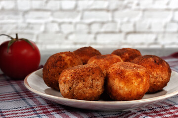 Delicious hot italian arancini - rice balls stuffed with cheese in a plate on an old wooden table