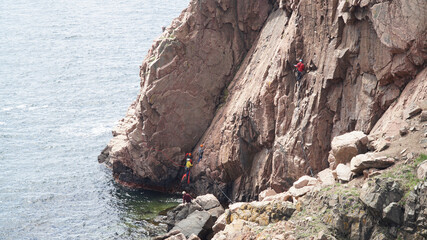 Climbers doing rock climbing on a steep rock in the Kullaberg Nature Reserve in Sweden.