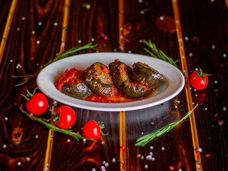 Caucasian eggplants on a white plate. Georgian food. Side view on a wooden table.