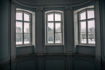 Vintage windows inside a beautiful old abandoned manor house. Street view.