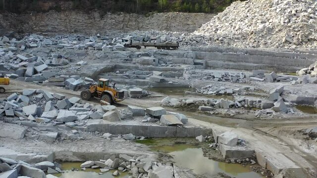 bulldozer rides on a marble quarry, a stone in the bucket