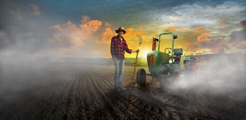 Fototapeta premium Old farmer with dung cable at work in the morning with fog and oldtimer tractor on the field -preparation of the land for sowing in the fall.