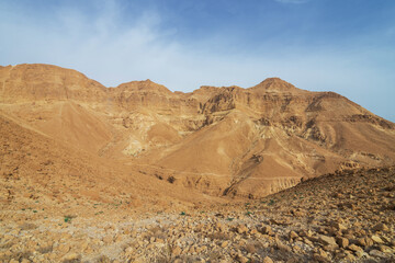 Sheer cliff of a mountain range with a trail on it. Wide angle.
