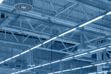 Supply and exhaust ventilation system with lights on ceiling of industrial building, exhibition hall or other commercial premise. Air conditioning in warehouse
