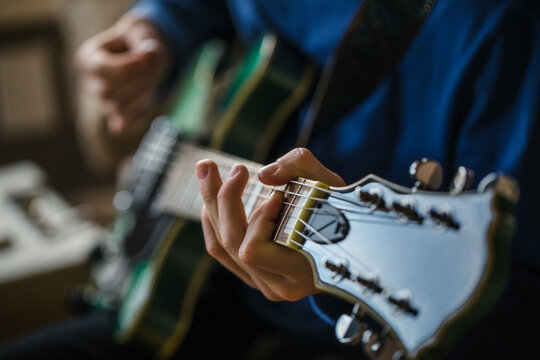 Close up of teen boy playing the guitar