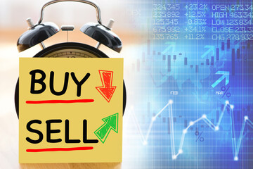 Perfect moment to Buy or sell stock exchange or shares concept with alarm clock with post it...