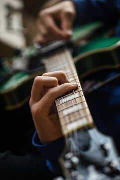 Close up of fingers, strings and frets of guitar