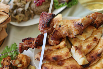 Dish with roasted young pig and bread pita. Food table background.