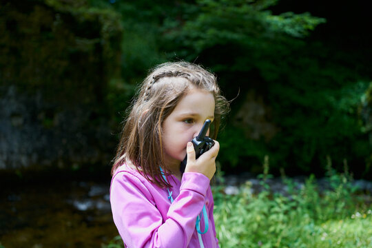 Beautiful Young Girl Using A Walkie-Talkie On Forest