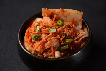 Kimchi in black bowl. Traditional Korean food