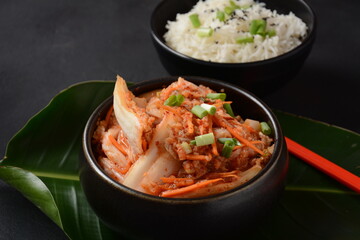 Kimchi and rice in black bowl with chopstick. Korean food
