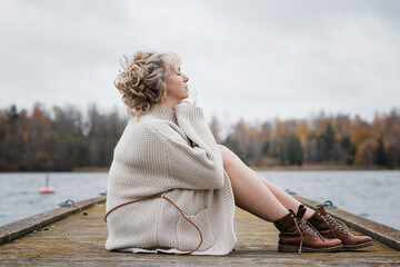 woman sat outside breathing in the fresh air looking thoughtful