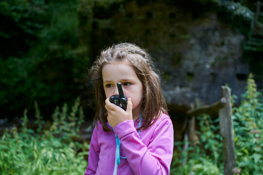Beautiful Young Girl Using A Walkie-Talkie On Forest