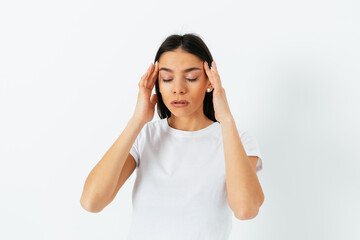 Portrait of a young woman with a headache in a t-shirt
