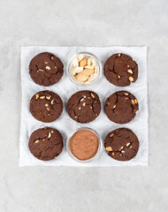 Vegan dessert chocolate cookies with peanuts on baking paper on a light gray background top view