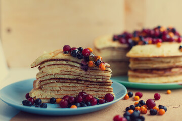 Traditional pancakes for maslenitsa with sea buckthorn cranberries and blueberries