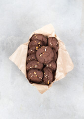 Cocoa cookies with whole peanuts in a wooden box on a light background top view