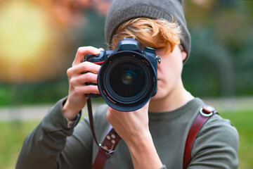 Woman taking pictures outdoors with analog camera, close up lens, photographer.