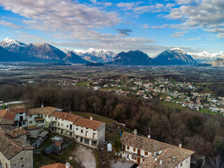 Fototapeta na wymiar Panoramic from above on the ancient village of San Lorenzo di Buja and on the snow-capped mountains.