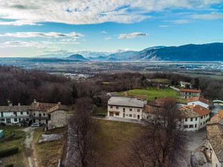 Fototapeta na wymiar Panoramic from above on the ancient village of San Lorenzo di Buja and on the snow-capped mountains.