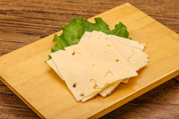 Sliced yellow cheese over board