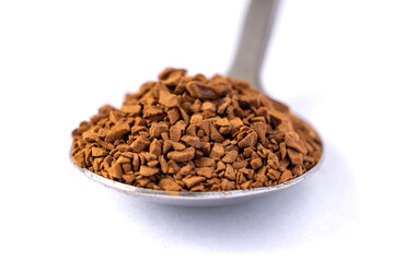 Freeze dried coffee. Metal spoon with granulated Instant Coffee close-up on white