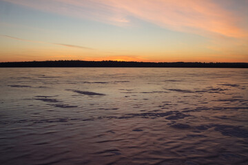 Ice on the lake at sunset. Winter background. Copy Space