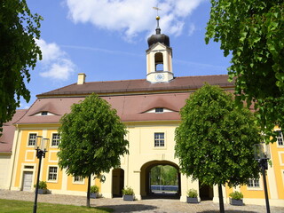 Gebäude des dreiflügeligen Wirtschaftshofes mit zentralem Torhaus und Torbogen