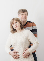 middle aged couple on white wall background
